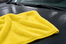 Lemon-yellow high-low plush microfiber towel on a wet car hood